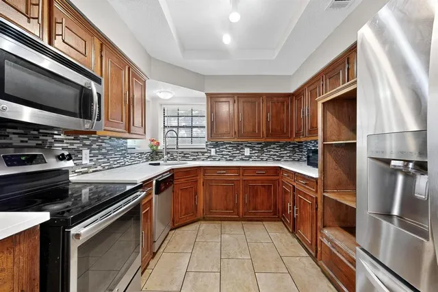 a kitchen with stainless steel appliances granite countertop a sink stove and microwave