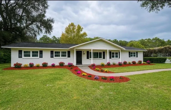 a front view of a house with porch and garden