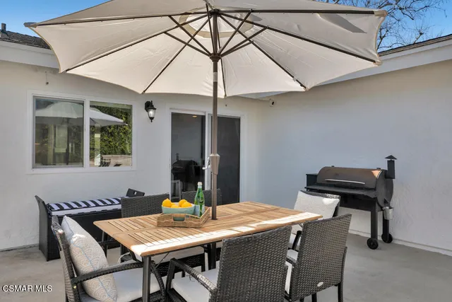 a kitchen with stainless steel appliances a refrigerator a stove a dining table and chairs with wooden floor