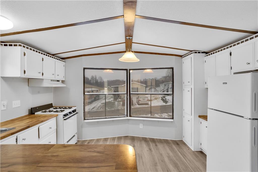 111 Dancer Lane Jeannette, PA 15644 - Photo 12 of 26 a kitchen with stainless steel appliances granite countertop a stove a refrigerator and a white cabinets with wooden floor