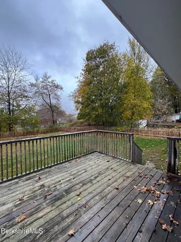 a balcony with wooden floor and fence