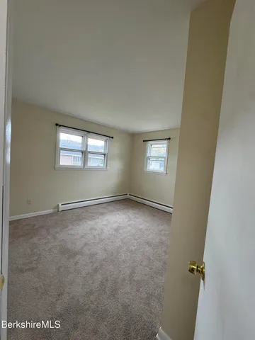 an empty room with windows and closet