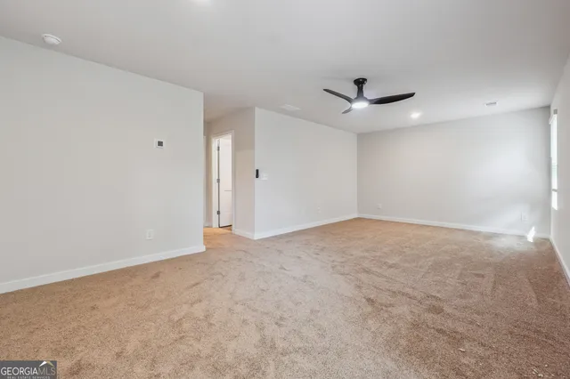 an empty room with a ceiling fan and a window