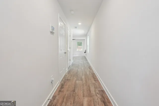 a view of a hallway with wooden floor