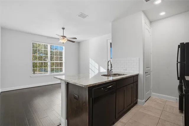 a kitchen with stainless steel appliances granite countertop a sink and a refrigerator