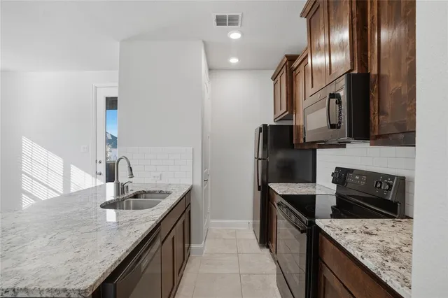a kitchen with granite countertop stainless steel appliances and sink