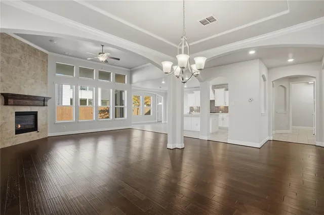 an empty room with wooden floor chandelier and livingroom view