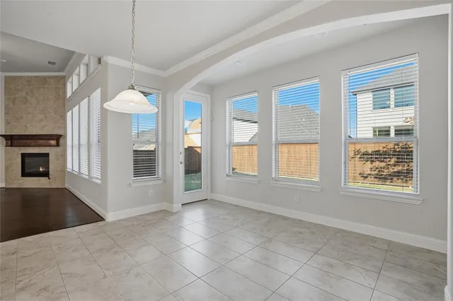 a view of an empty room with a window and fireplace