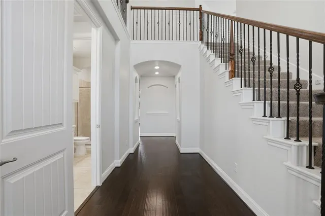 a view of a hallway with wooden floor and entryway