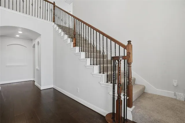 a view of staircase with wooden floor and white walls