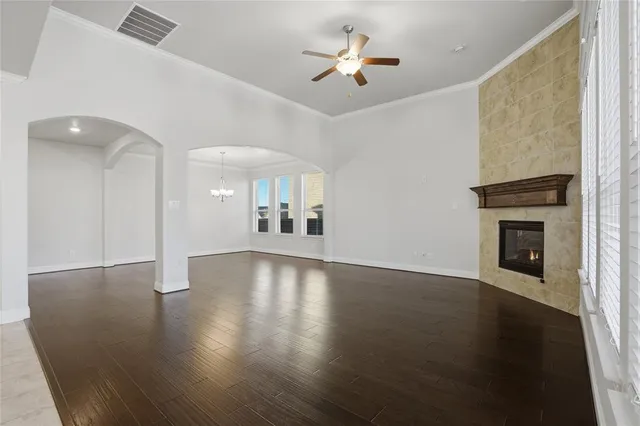 a view of a livingroom with wooden floor and a kitchen