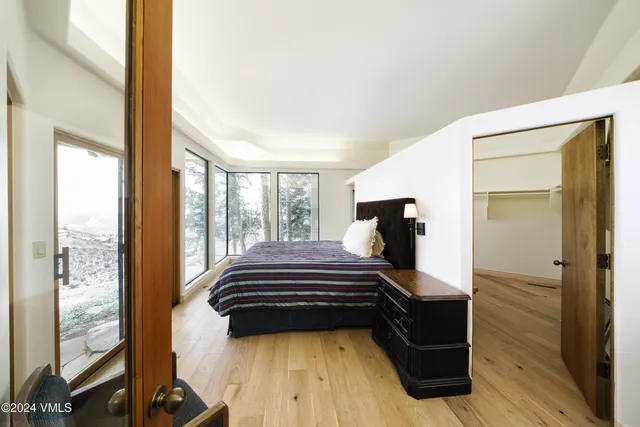 a spacious bedroom with a bed and wooden floor