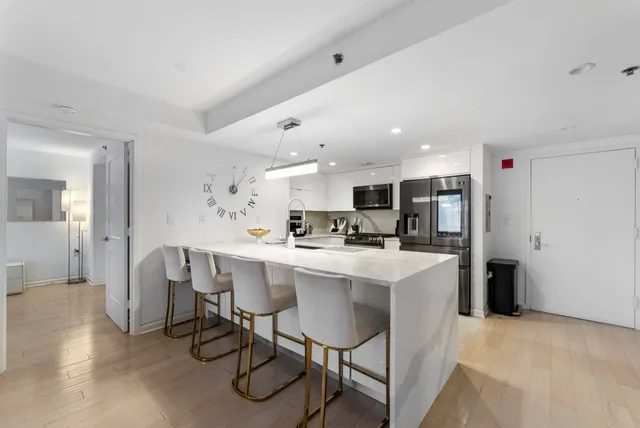 a kitchen with a dining table chairs cabinets and stainless steel appliances