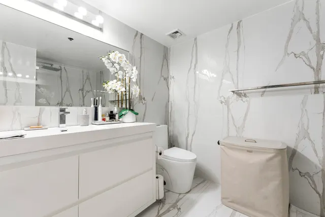 a bathroom with a toilet sink and mirror