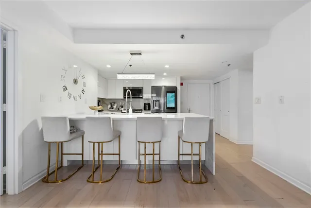a kitchen with a table chairs refrigerator and cabinets