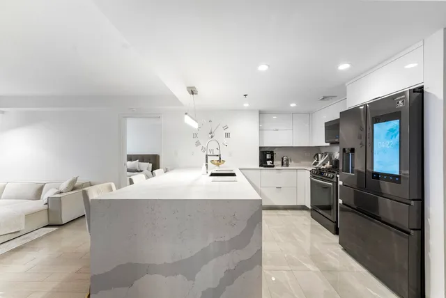 a large kitchen with kitchen island a sink stainless steel appliances and cabinets