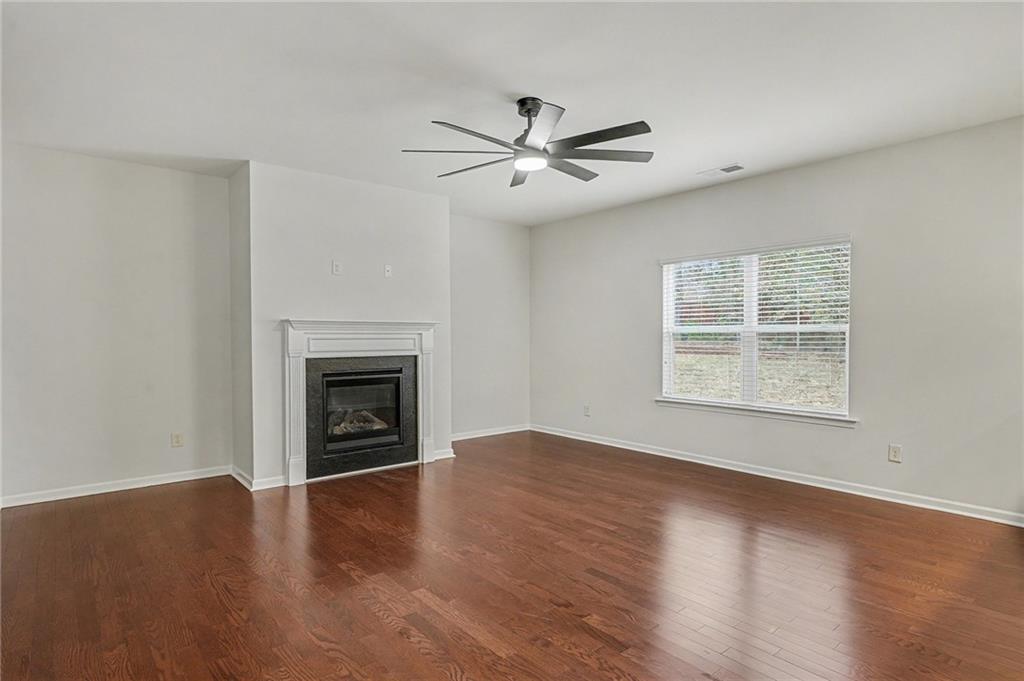 321 Lara Lane Hampton, GA 30228 - Photo 4 of 33 a view of an empty room with wooden floor fireplace and a window