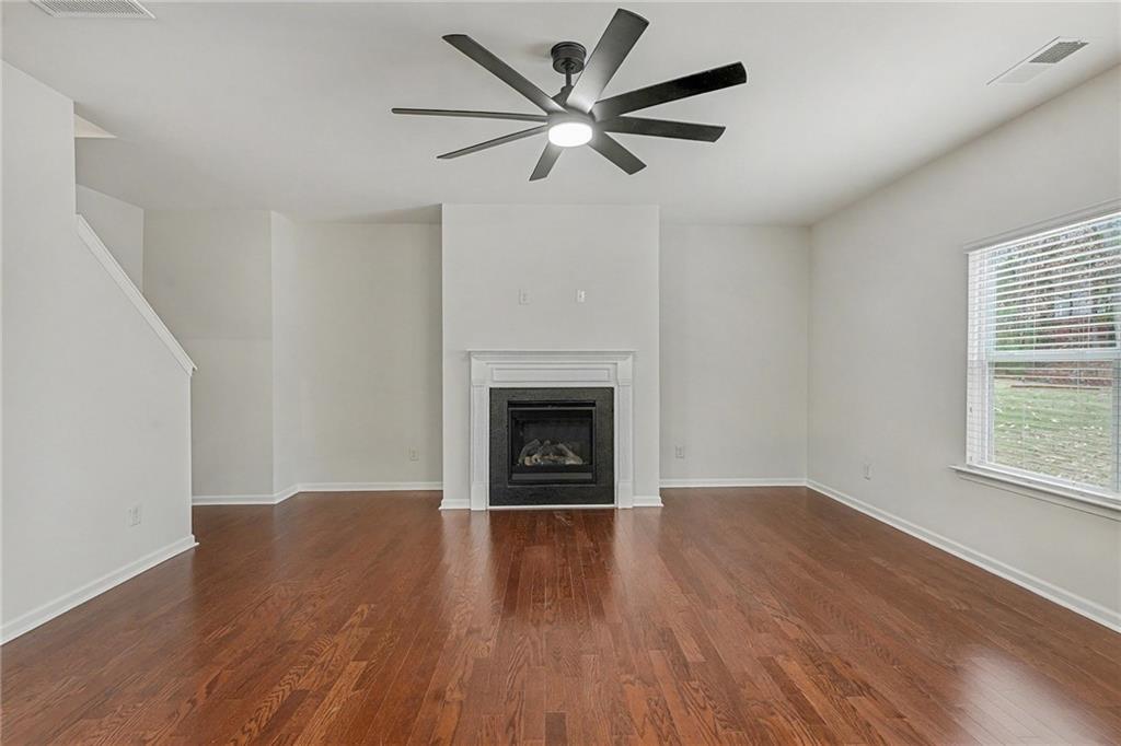 321 Lara Lane Hampton, GA 30228 - Photo 5 of 33 a view of an empty room with wooden floor a ceiling fan and a window