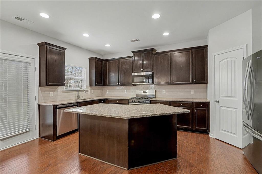 321 Lara Lane Hampton, GA 30228 - Photo 7 of 33 a kitchen with stainless steel appliances granite countertop a sink stove and refrigerator