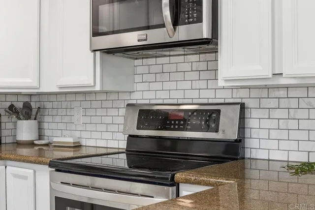 a bedroom with a baby bed a couch and a window