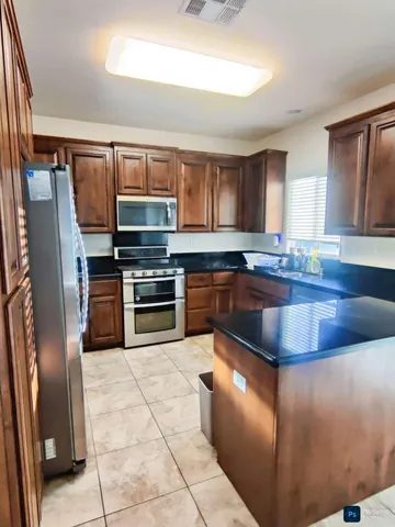 a kitchen with stainless steel appliances granite countertop a sink a stove and a refrigerator