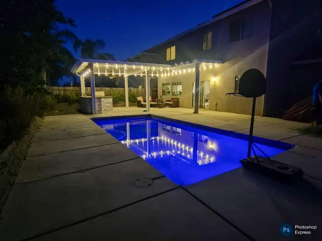 a view of swimming pool with red chairs