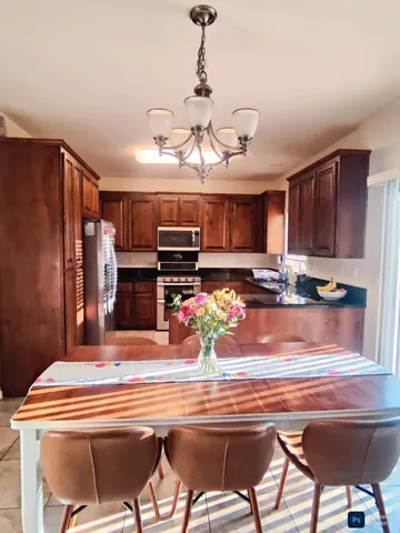 a kitchen with stainless steel appliances granite countertop a sink and a refrigerator