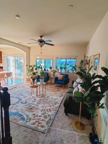 a living room with furniture a patio and a floor to ceiling window