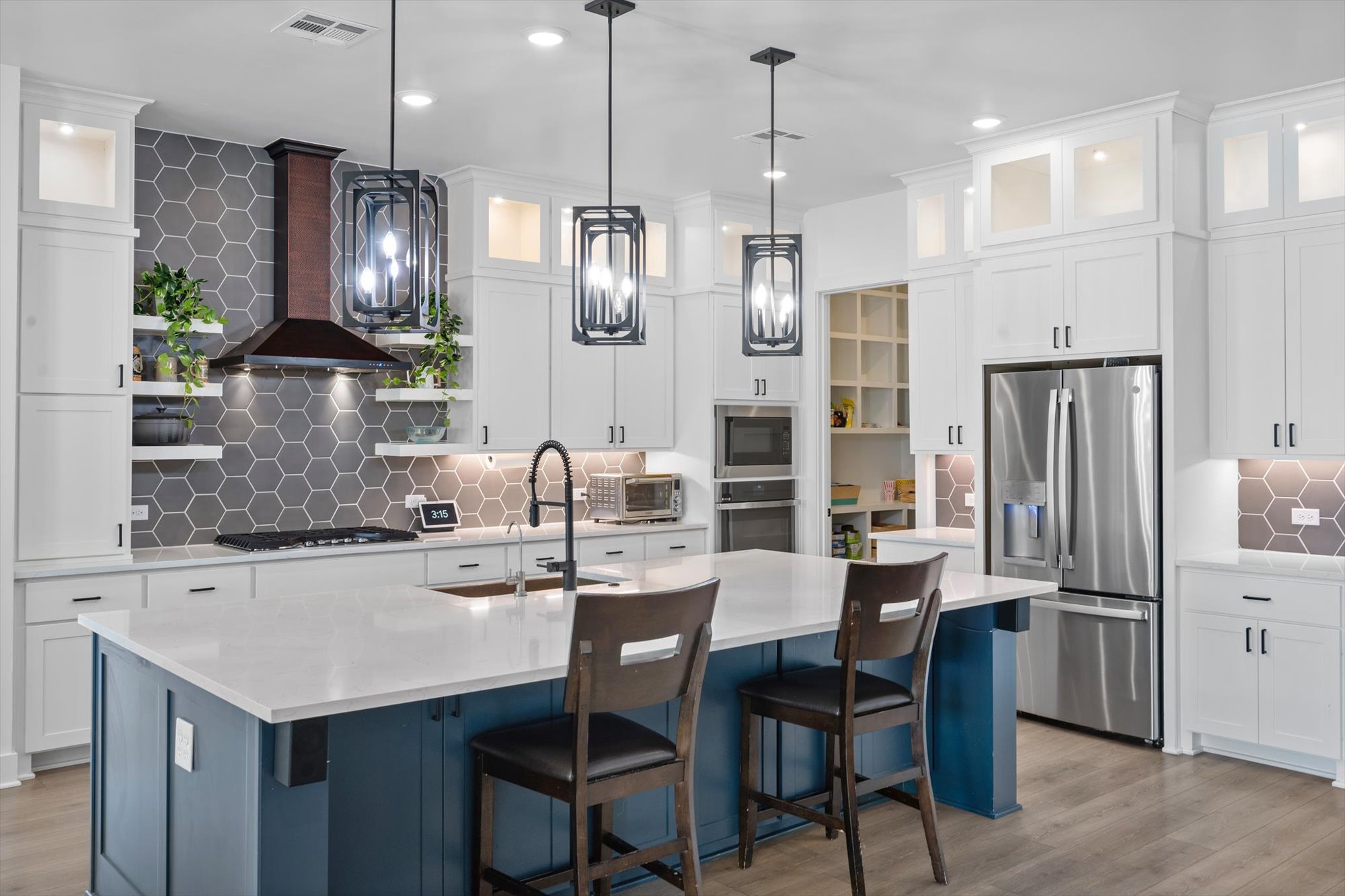 638 Strada Luca Florence, TX 76527 - Photo 8 of 38 A well-appointed kitchen features a large central island, stainless steel appliances, and sleek pendant lighting.