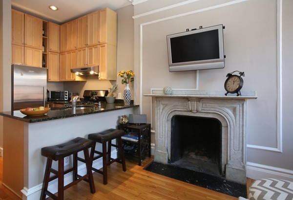 235 Beacon Street, Unit 7 Boston, MA 02116 - Photo 2 of 7 a living room with furniture a flat screen tv and a fireplace