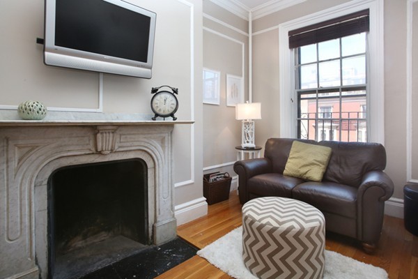 235 Beacon Street, Unit 7 Boston, MA 02116 - Photo 4 of 7 a living room with furniture a fireplace and a flat screen tv
