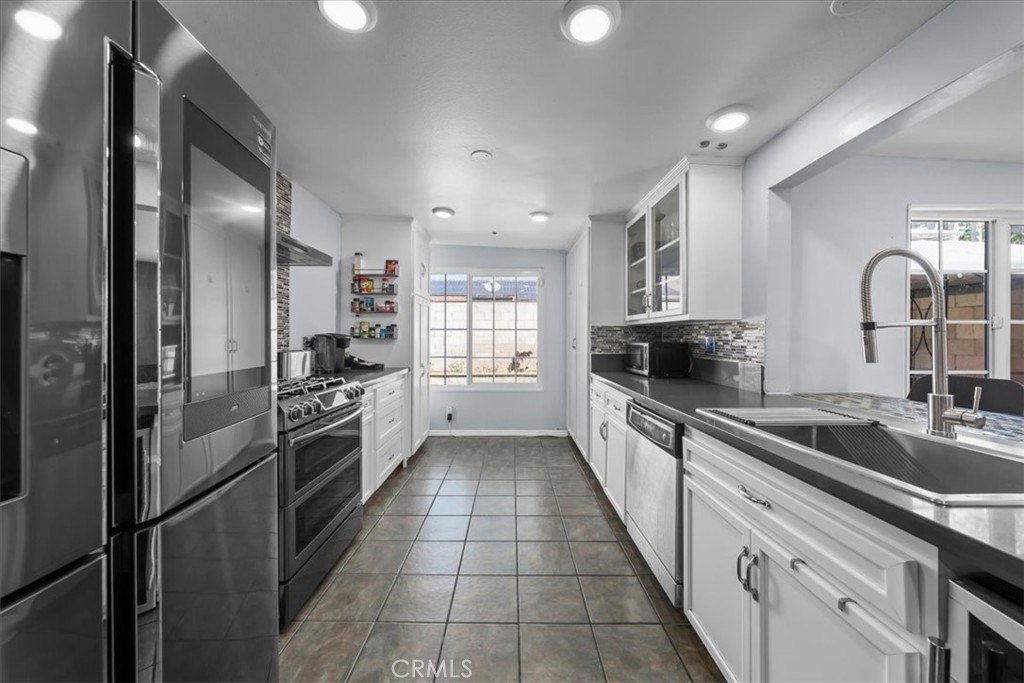 1733 East Dimondale Drive Carson, CA 90746 - Photo 13 of 43 a large kitchen with a refrigerator a sink a stove top oven and cabinets
