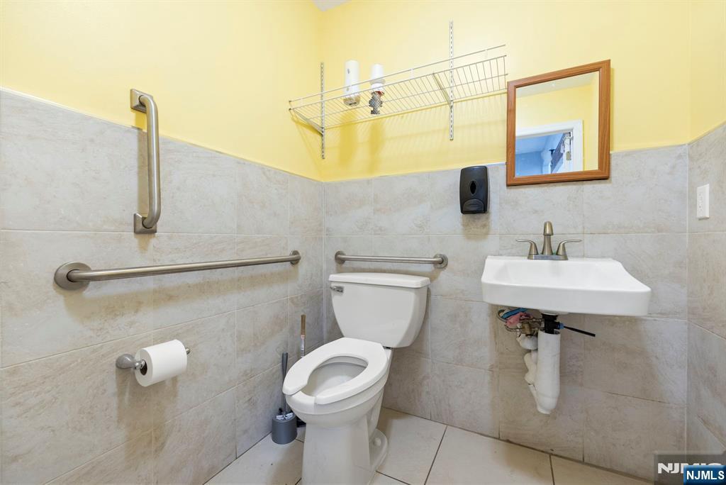 67 Broadway Newark, NJ 07104 - Photo 15 of 18 a bathroom with a sink a toilet and mirror