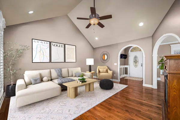 an empty room with wooden floor fireplace and fan