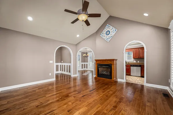 a view of an empty room with window and wooden floor