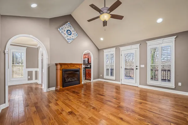 an empty room with ceiling fan and windows