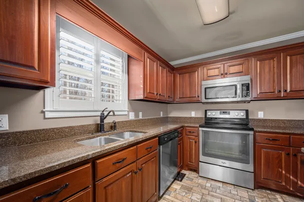 a kitchen with stainless steel appliances granite countertop a sink stove and refrigerator