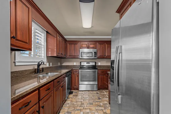a kitchen with stainless steel appliances granite countertop a sink stove and cabinets