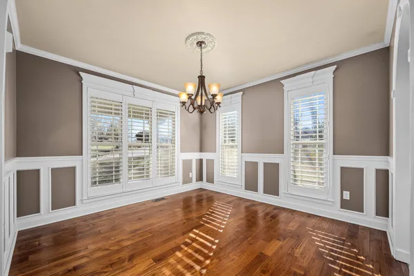 a dining room with furniture potted plants and wooden floor