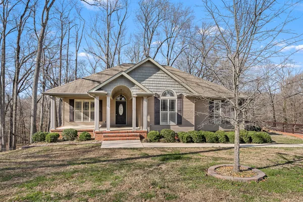 a front view of a house with yard and green space