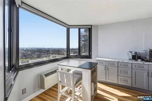 a kitchen with a stove a sink and white cabinets with wooden floors