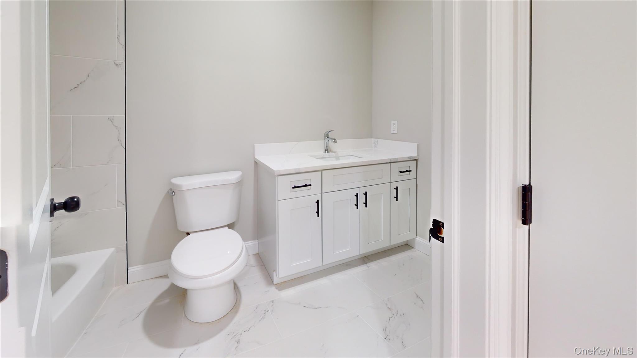 492 Blue Point Road Farmingville, NY 11738 - Photo 16 of 21 a spacious bathroom with a toilet sink and a mirror