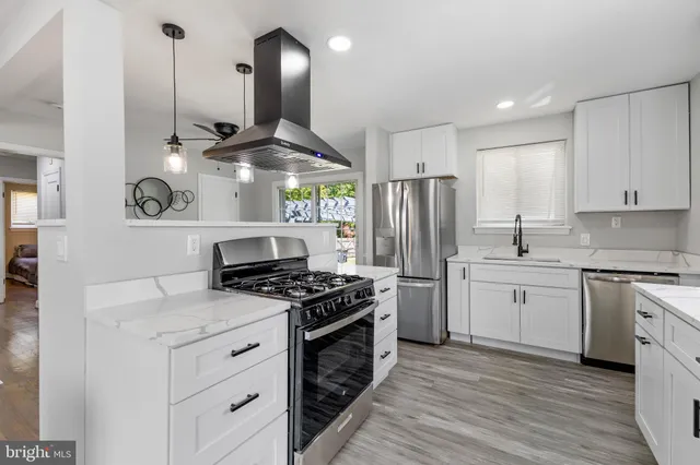 a kitchen with stainless steel appliances granite countertop a stove a sink and a refrigerator