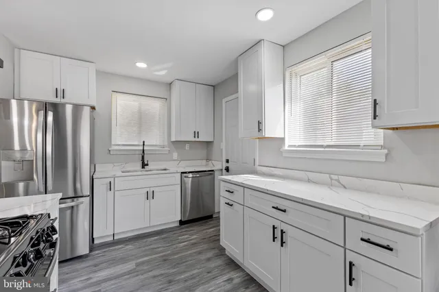 a kitchen with white cabinets and appliances