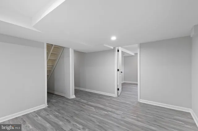 a view of an empty room with wooden floor and closet