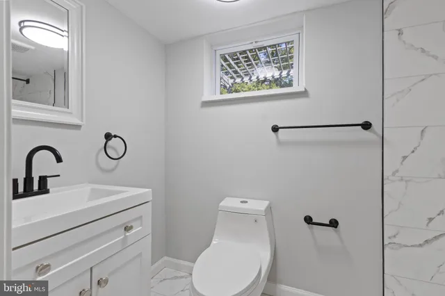 a bathroom with a toilet sink and mirror