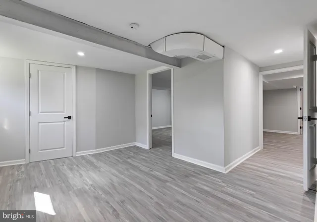 an empty room with wooden floor and mirror