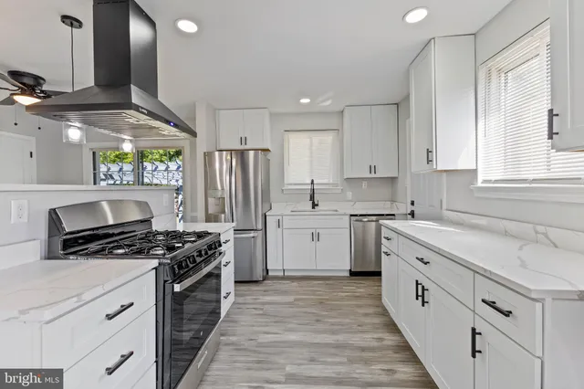a kitchen with stainless steel appliances a stove a sink and a refrigerator