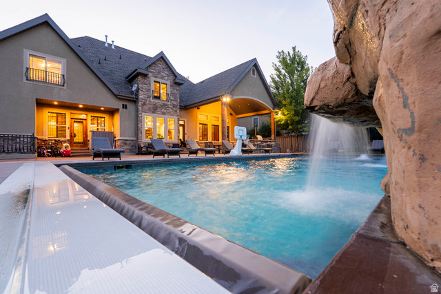 687 South 2080th Street East Springville, UT 84663 - Photo 139 of 149 Backyard oasis featuring a swimming pool with a rock waterfall and integrated pool cover
