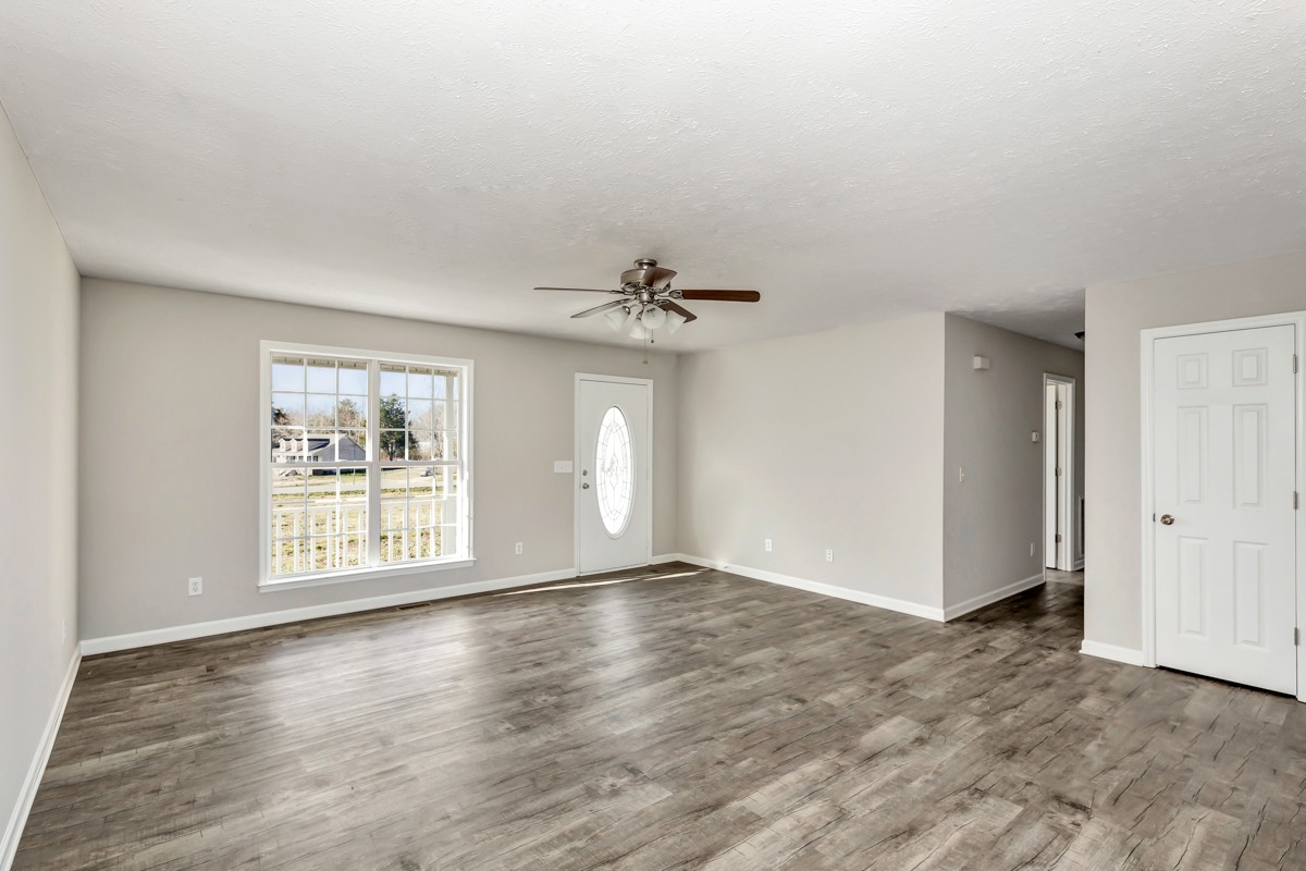 244 East Prospect Road Fayetteville, TN 37334 - Photo 9 of 24 an empty room with wooden floor chandelier fan and windows